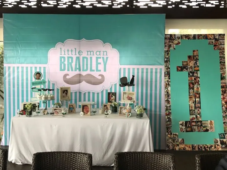 Bàn tiệc sinh nhật phủ khăn trắng trước phông sọc xanh ngọc